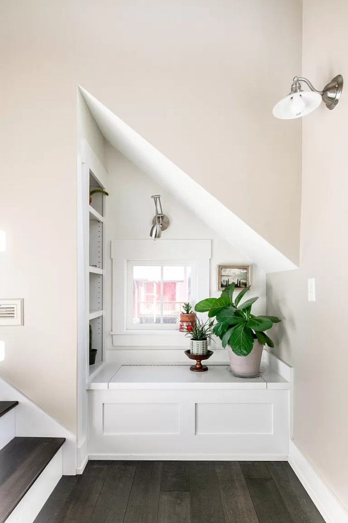 Built-in window seat under eaves on stair landing.