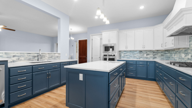 Navy blue and white kitchen with wood floors and brushed nickel accents.